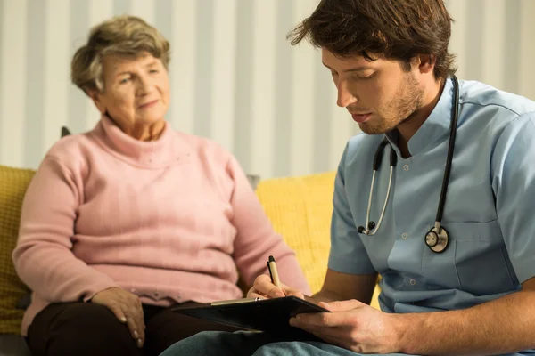 Doctor during visit at home — Stock Photo, Image