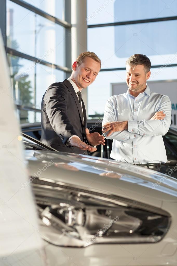 Smiling car salesman with customer