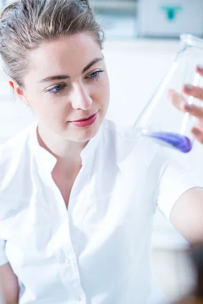 Женщина-ученый держит стеклянную посуду — стоковое фото