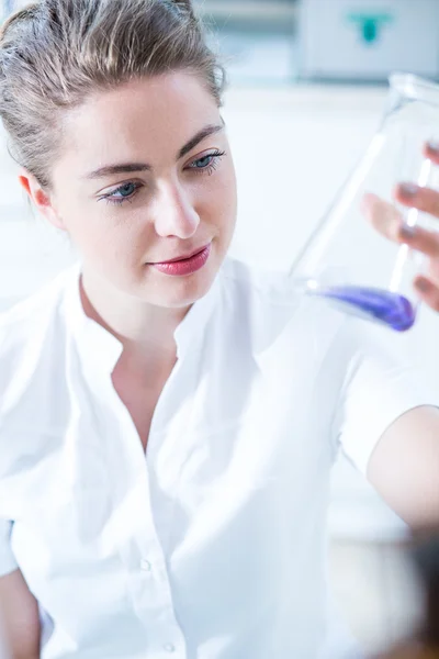 Mujer científica sosteniendo utensilio de vidrio — Foto de Stock