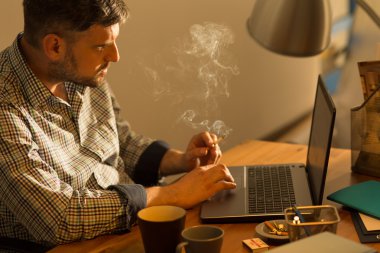 Laptop oturmuş sakallı erkek