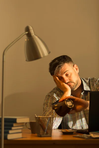 Exhausted man sitting at desk — Stock Photo, Image