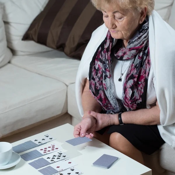 Mujer mayor jugando a las cartas sola — Foto de Stock