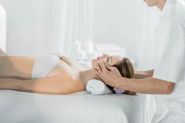 Massagista fazendo massagem facial — Fotografia de Stock