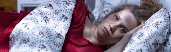 Scared young girl in bed — Stock Photo, Image