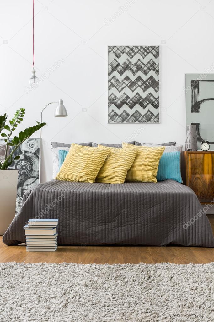 Bed with decorative yellow pillows