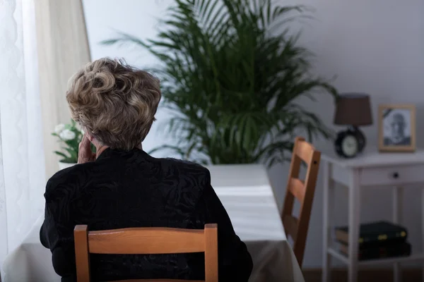 Elderly widow sitting alone — Stock Photo, Image