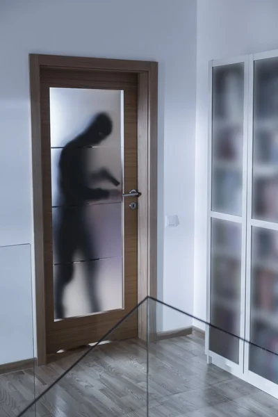 Armed burglar breaking into house — Stock Photo, Image