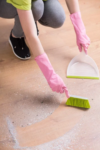 Person reinigt Boden mit Kehrschaufel — Stockfoto