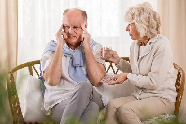 Жена помогает мужу справиться с головной болью — стоковое фото