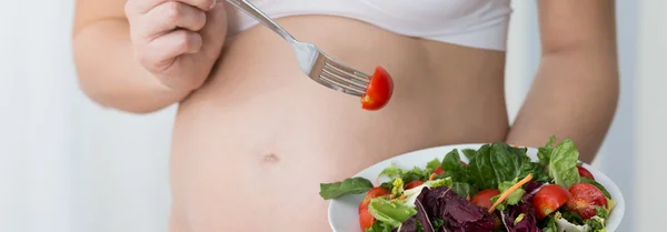 Gravid kvinna äter sallad — Stockfoto