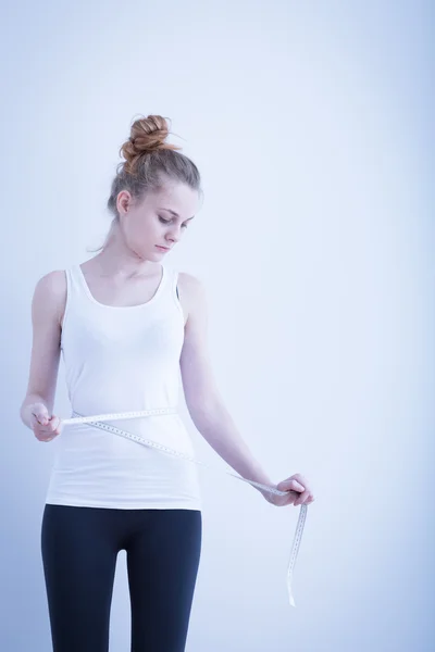 Slim meisje haar taille meten — Stockfoto