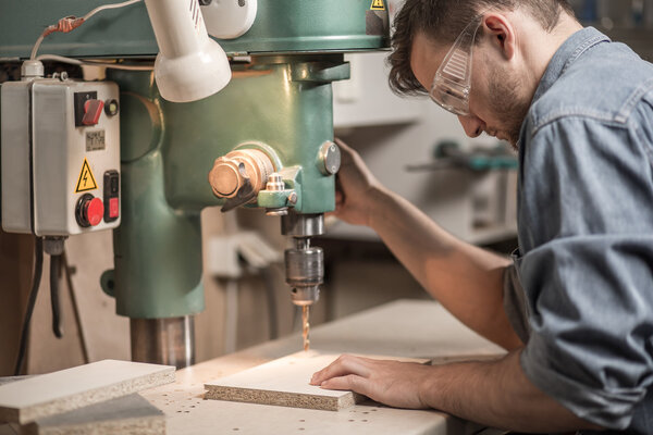 Joiner drilling wooden board