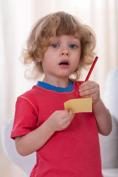 Jongen met papier en pen — Stockfoto