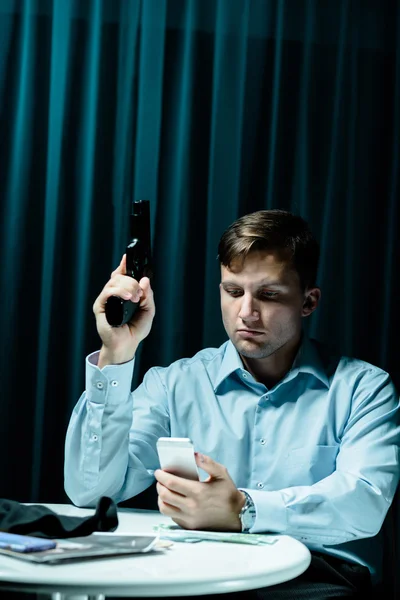 Stalker with gun and phone — Stock Photo, Image