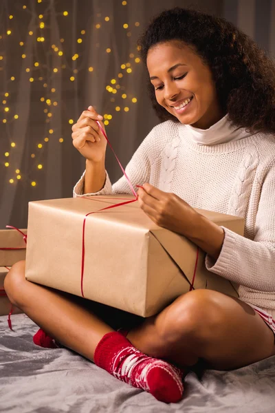 Дівчина розпаковує різдвяну подарункову коробку — стокове фото