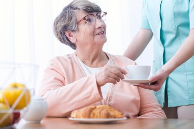 Yaşlı kadın çay içiyor.