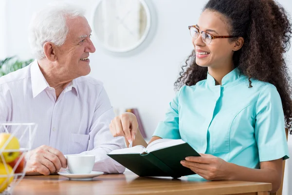 Caregiver keeping senior man company — Stock Photo, Image