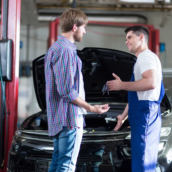 Mechaniker übergibt Kundenschlüssel — Stockfoto