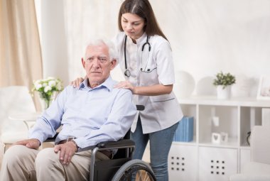 Tekerlekli sandalye üzerinde yaşlı adamla hemşire