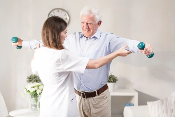 Enfermera ayudando al paciente a hacer ejercicio — Foto de Stock