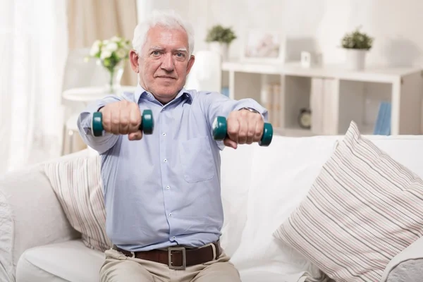 Elderly man exercising at home — Stock Photo, Image