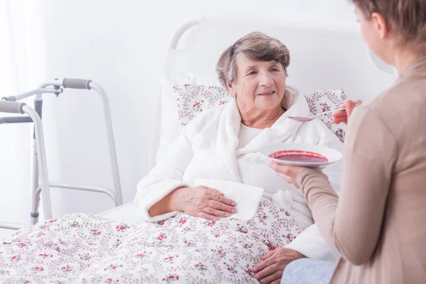 Granddaughter helping her ill grandmother — Stock Photo, Image