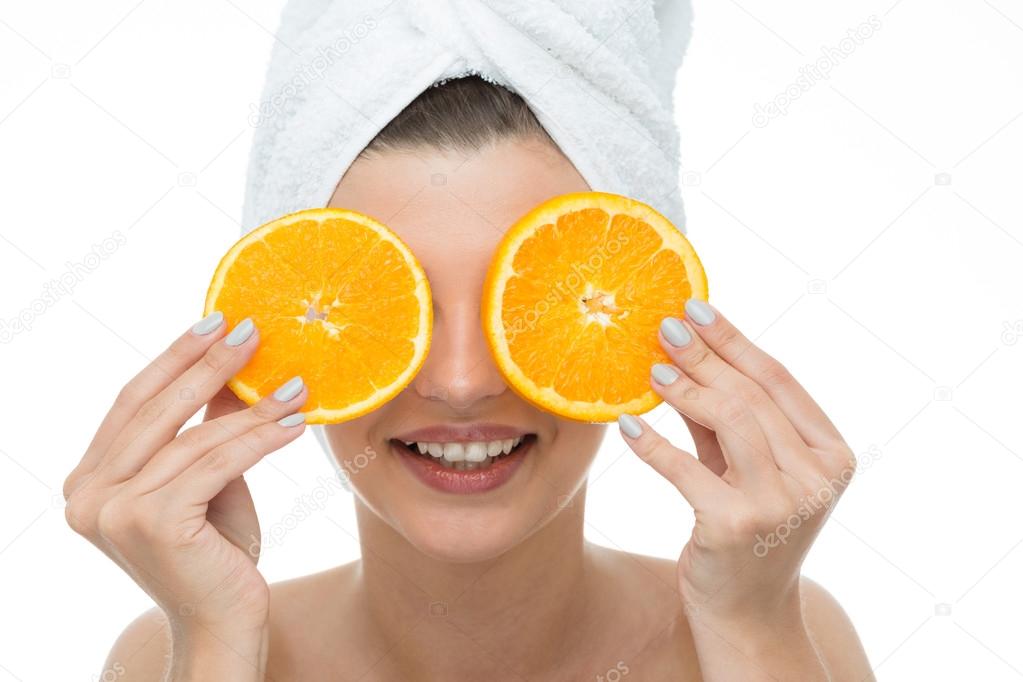Laughing female holding orange slices