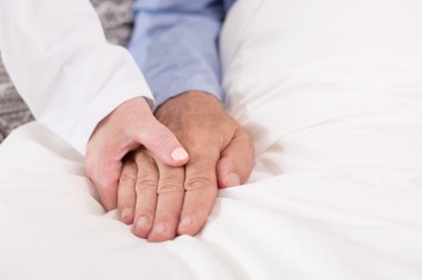 Hasta adamın elini tutarak