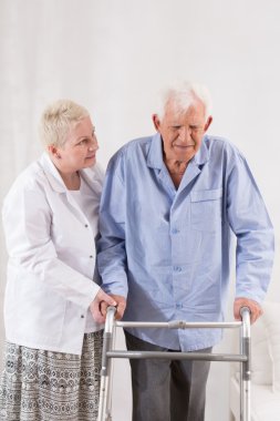 Yürüyen bir çerçeve kullanan engelli adam