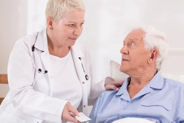 Krankenschwester gibt Tabletten an Seniorin — Stockfoto