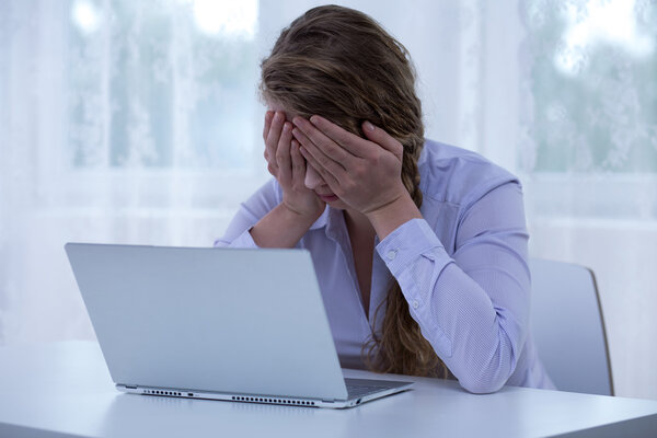 Despair cyberbullying victim covering eyes