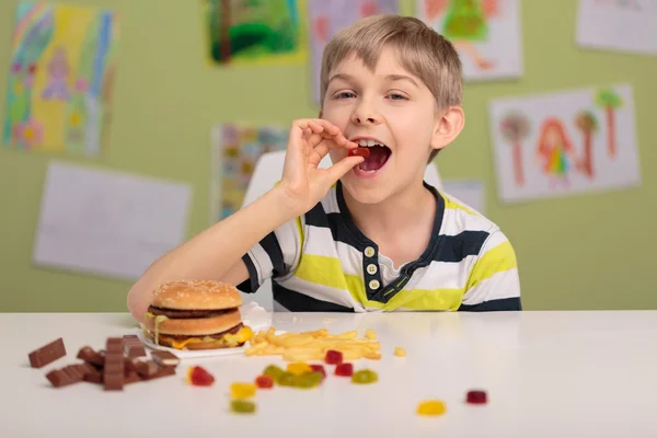 Enfant mangeant des bonbons et fastfood — Photo