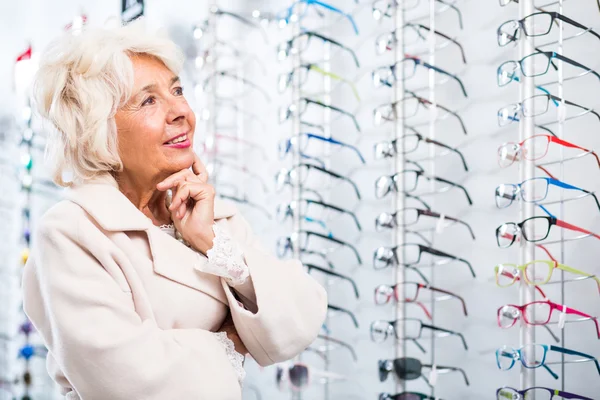 Oudere vrouw in optische winkel — Stockfoto