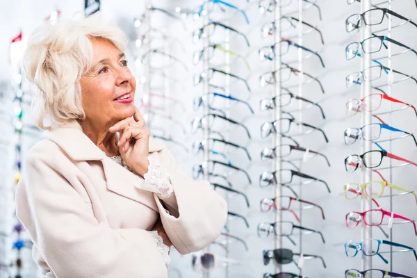 Donna anziana al negozio di ottica — Foto Stock