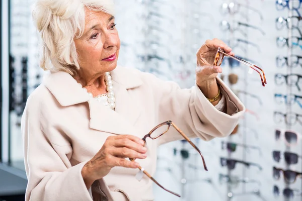 Opticians feminino paciente comprando óculos — Fotografia de Stock