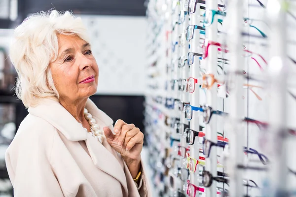 Señora mayor en la tienda de gafas — Foto de Stock