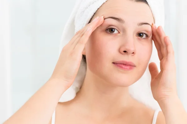 Young woman applying facial cream — Stock Photo, Image