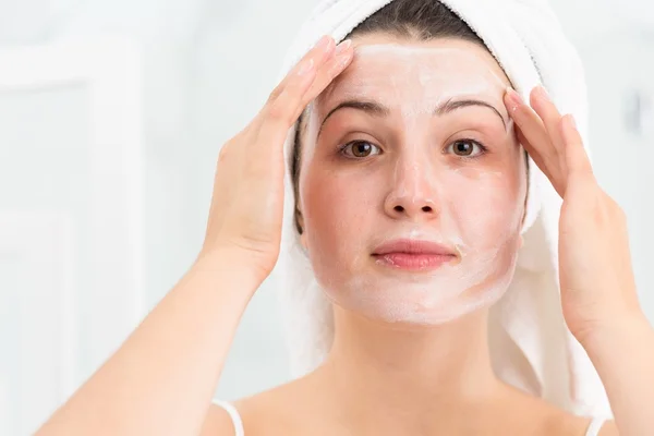 Mulher aplicando máscara facial — Fotografia de Stock