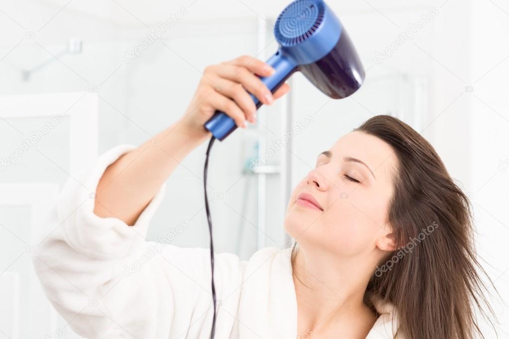 Girl drying hair in bathroom