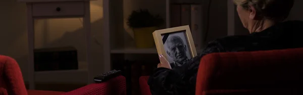 Vedova anziana con foto in mano — Foto Stock