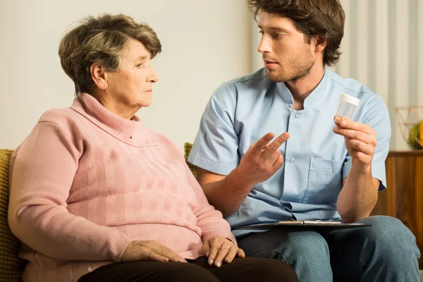 Male carer supporting old woman — Stock Photo, Image