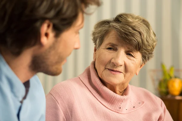 Mujer anciana positiva con cuidador —  Fotos de Stock