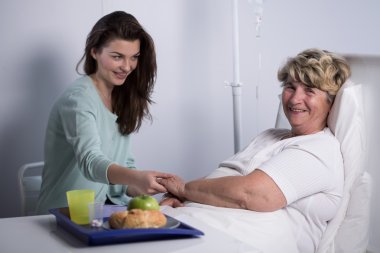 Elderly patient with her caregiver clipart