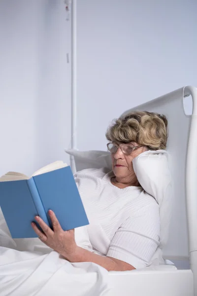 Senior vrouw leest in bed — Stockfoto