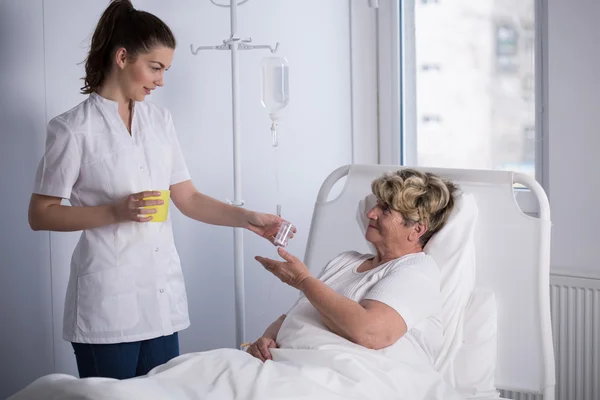 Медсестра дает лекарства пациенту — стоковое фото