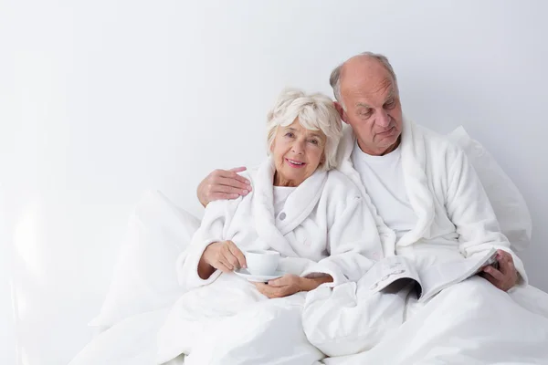 Старший брак лежит в постели — стоковое фото