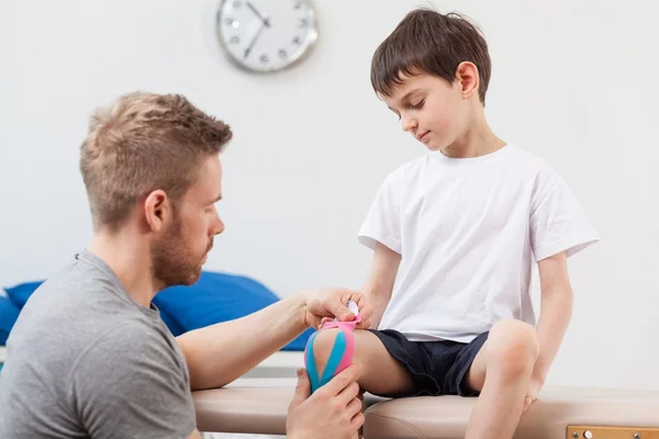 Fyzioterapeut tejpování dítě — Stock fotografie