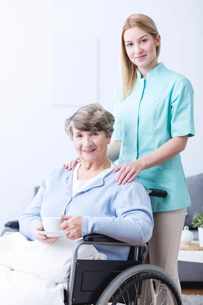 Jonge mantelzorger en senior vrouw — Stockfoto