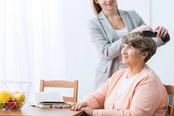 Kleindochter kammen oma's haar — Stockfoto